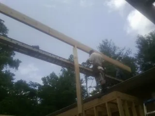 Carpenter setting a ridge beam over a new addition frame — Ice Dam Removal by Roofing Brothers in Dillard