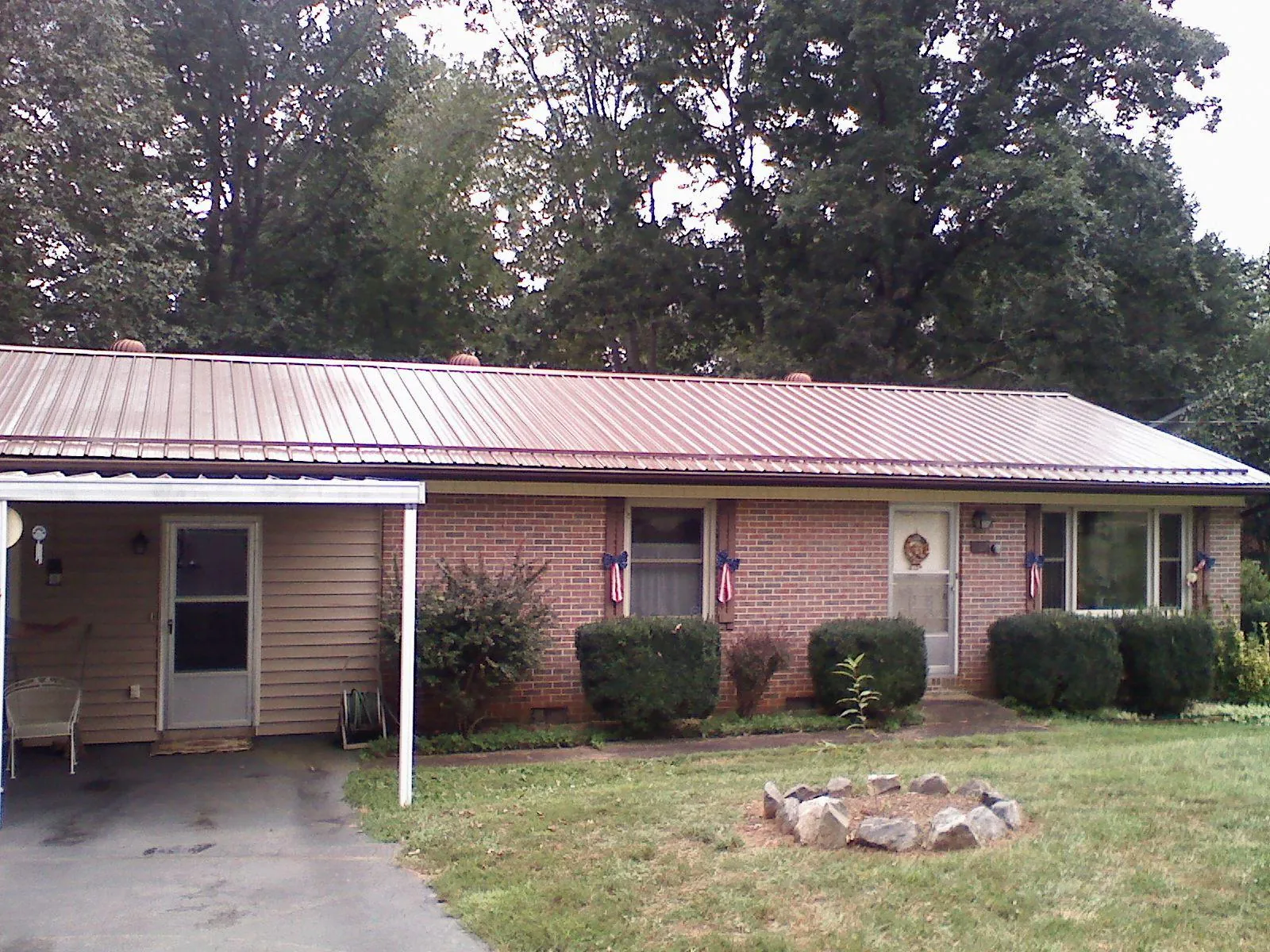 Bronze metal roof and carport on a brick ranch home — Roof Repair work by our crew in Dillard